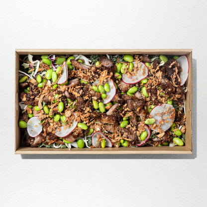 Beef with slaw, shaved carrot, radish, red onion, kale, soy beans, toasted sesame seeds, crispy garlic & roasted sesame dressing