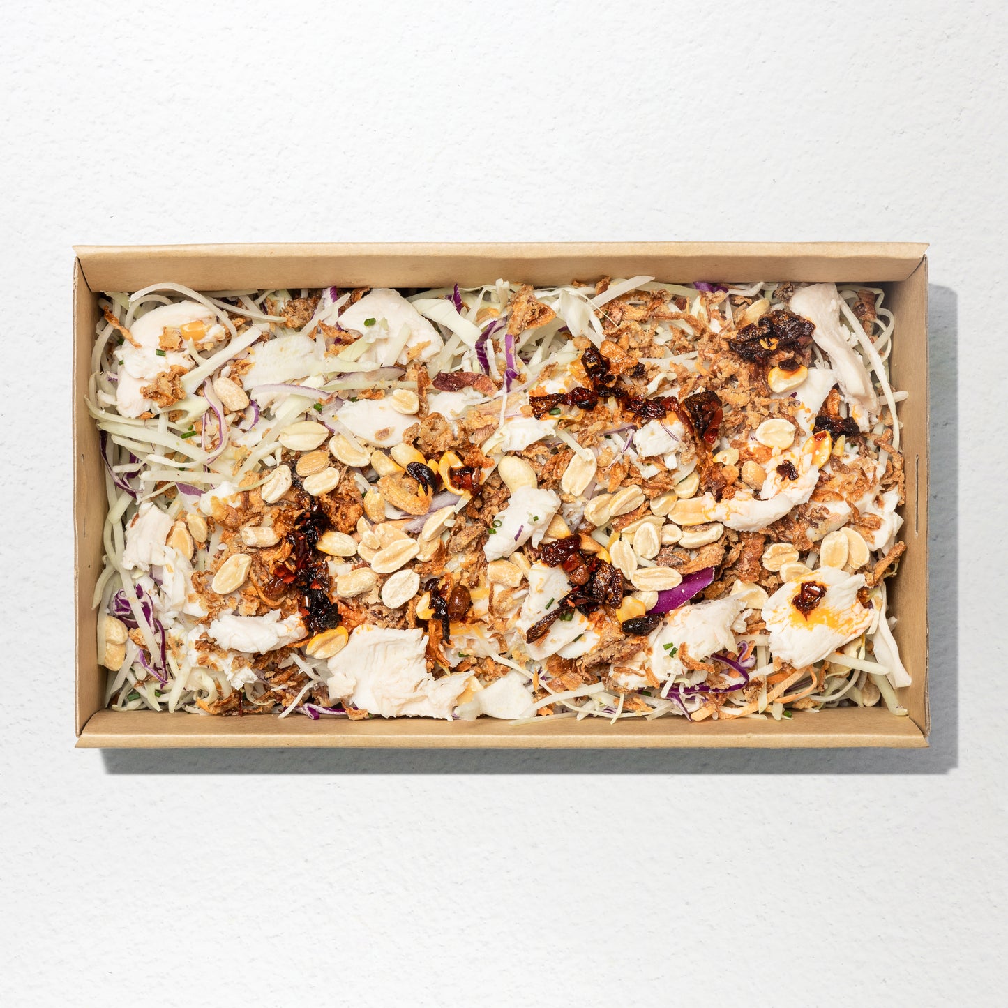 Papaya with shredded chicken, white cabbage, crispy shallots, crispy peanuts, roasted coconut, palm sugar & coconut cream dressing